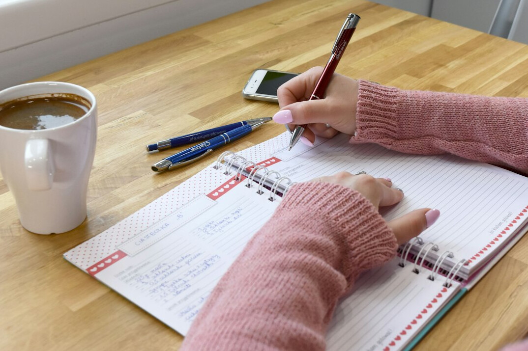 person writing goals in notebook