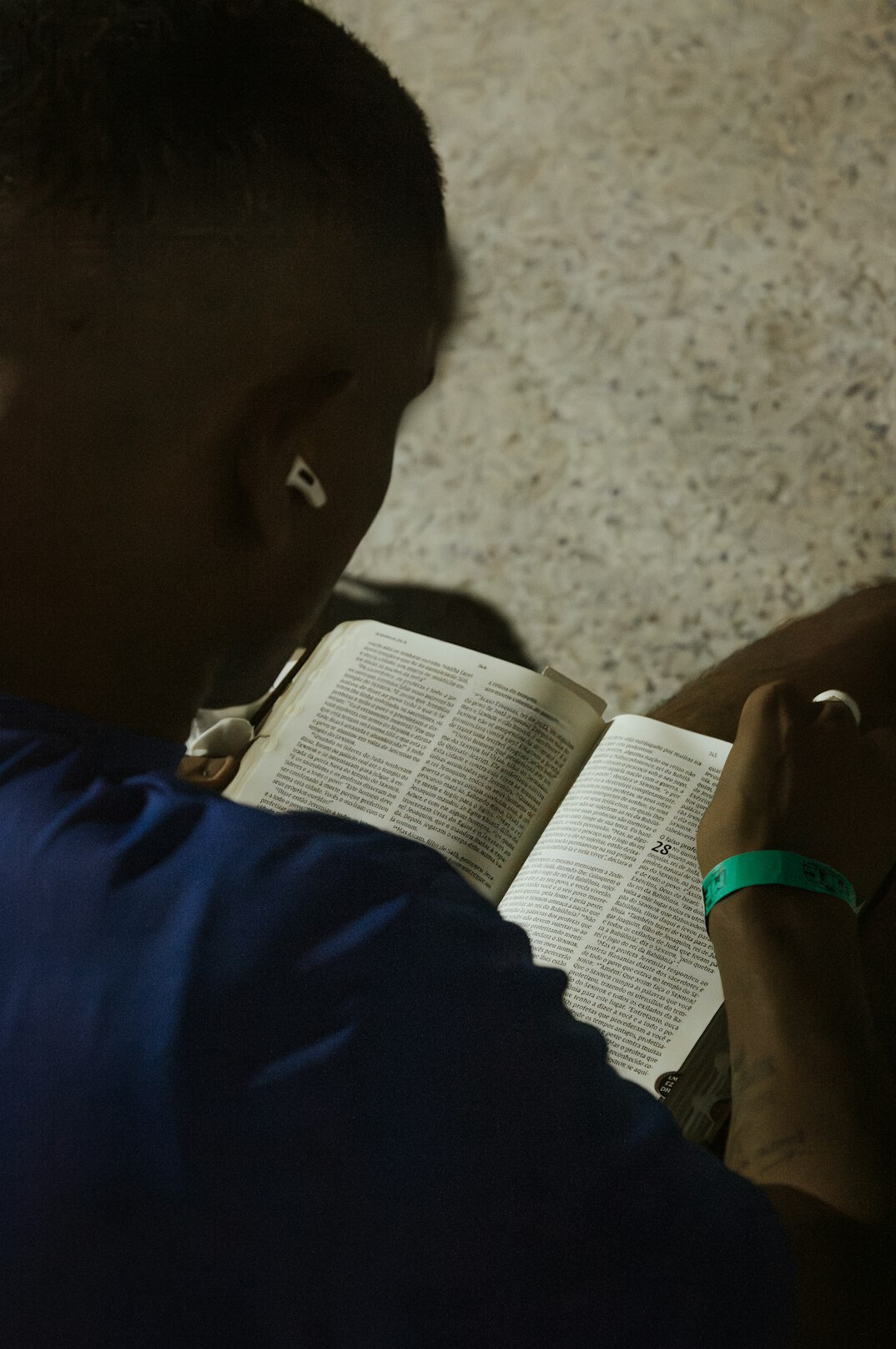 Brazilian man writing notes in a notebook at a wooden desk